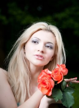Beauty Blonde Woman With Roses In Hands. Close-Up Portrait
