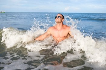 Happy young muscular male enjoying the sea