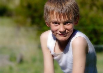 image of a boy in a singlet looking at the camera. boy looking at camera