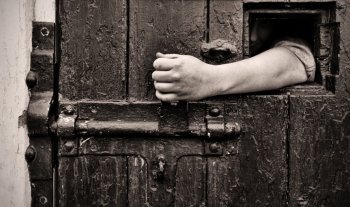 escape arm reaches through jail window to open the door
