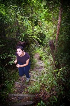 An active young woman hiking in thick jungle