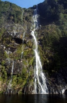 Long, thin waterfall cascades down the mountainside.