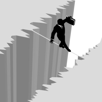 A business man takes a risky dangerous walk on a tightrope over a cliff drop off to safety.