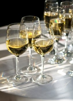 glasses of white wine illuminated by sunrays. glasses of white wine