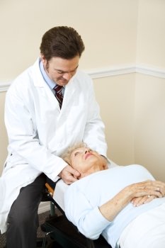 Senior woman gets her neck adjusted by a caring chiropractor.  