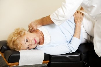Senior woman getting an adjustment from her chiropractor.  