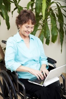 Disabled businesswoman using a tiny netbook computer. 