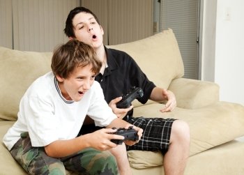 Two boys playing video games with intense competition.  