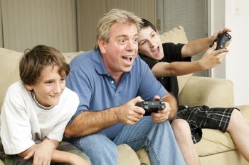 Uncle and his two nephews playing video games together.  Could also be father and sons.  