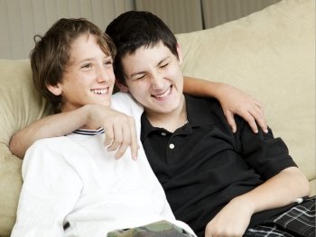 Two young brothers laughing together at home.  
