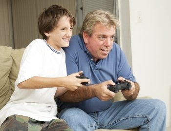 Father or uncle playing video games with a little boy - his son or nephew.  