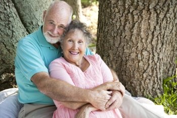 Beautiful senior couple in love, embracing under a tree.  