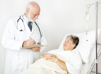 Doctor reviews his hospital patient’s medical history, taking notes.  