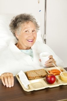 Senior woman in the hospital, eating her lunch from a tray.  