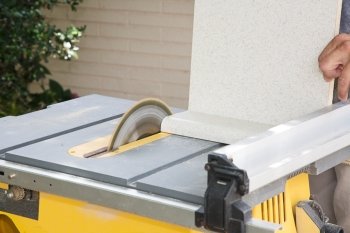 Carpenter uses a table saw to cut laminate counter top.  