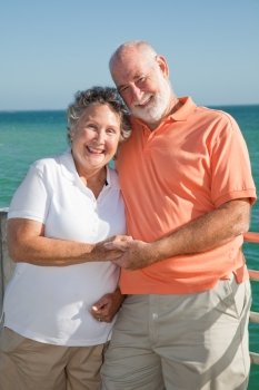 Portrait of a happy senior couple enjoying a seaside vacation.  