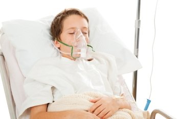 Little boy in the hospital breathing with the help of a respirator.  Isolated on white.  