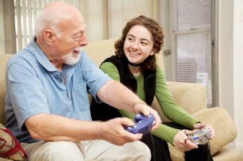 Grandfather spends quality time with his granddaughter playing video games.  