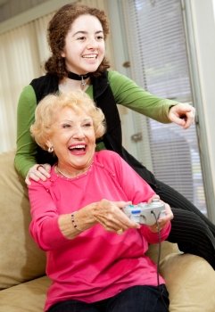 Grandmother and teen granddaughter having a great time playing video games.