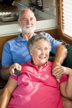 Retired senior couple watching television in their motor home.  
