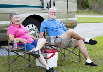Senior couple on vacation, relaxing outside their motor home.  