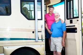Portrait of senior couple at the door of their recreational vehicle.  