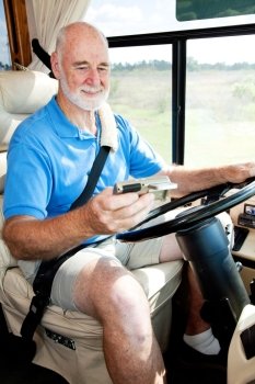 Senior man using GPS navigation to drive his motor home.  
