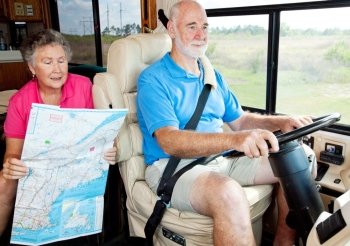 Senior couple on vacation in their motor home.  The wife is reading the map to her husband.