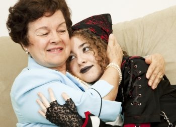 Mother and rebellious goth daughter hugging each other.  