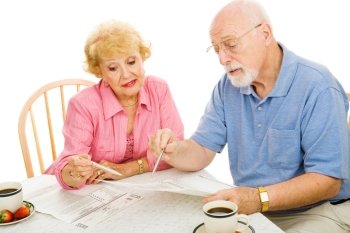 Senior couple filling out their absentee ballots at home.  Isolated on white.  