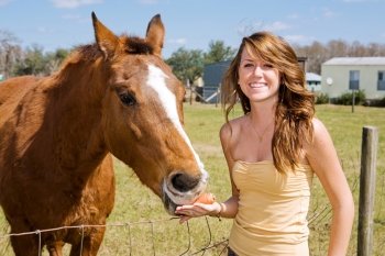 Beautiful teen girl on the farm with her horse.  