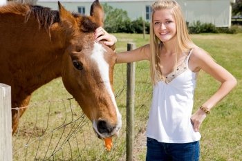 Beautiful teen girl on the farm with her horse.  