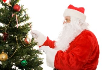 Santa Claus decorating a Christmas tree.  Isolated on white background.