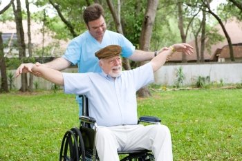 Disabled senior man does stretching exercise with the help of his physical therapist.  