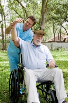 Physical therapist working with disabled senior man outdoors in a natural setting.  