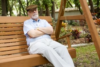 Senior man relaxing in the park with his eyes closed.  