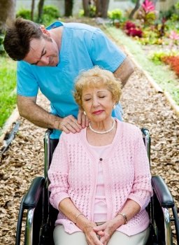 Senior woman in wheelchair receives massage therapy from a physical therapist.  
