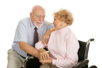 Loving senior couple coping with the wife’s disability.  Isolated on white.  
