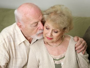 A senior man and wife deeply in love.  She is upset and he is comforting her.  