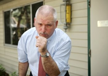 A businessman coughing with a severe chest cold.  