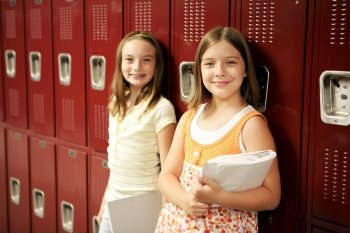 Two adolescent school girls in front of their lockers.  
