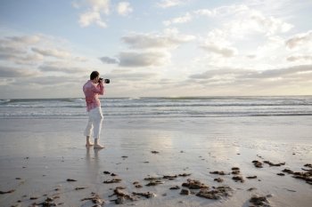 A photographer taking a photo on the beach.