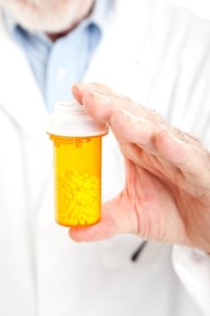 Closeup of a pharmacist’s hands holding a bottle of prescription pills.