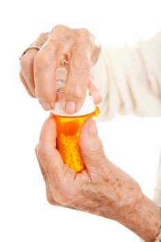 Closeup of senior woman’s hands trying to open a prescription bottle with childproof cap.  Isolated on white.