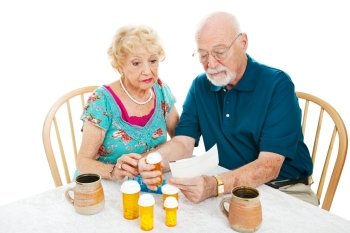 Senior couple reading instructions from the pharmacy on how to take their medication. White background.  