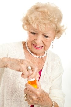 Senior woman struggling to open a childproof cap on her prescription bottle.  White background.  