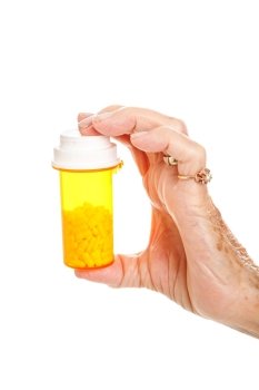 Closeup of a senior woman’s hand holding a bottle of pills.  Isolated on white.  
