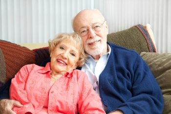 Retired senior couple relaxing together on their living room sofa.  