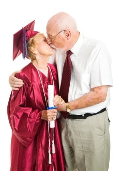 Senior woman gets a kiss from her husband on her graduation day.  Isolated on white.