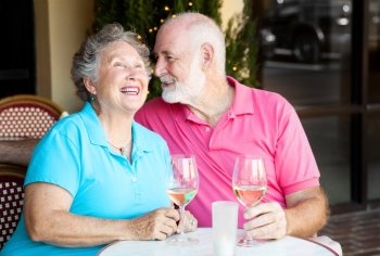 Senior couple at a cafe, enjoying wine and conversation together.  